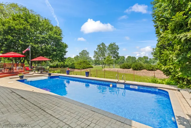 a kitchen with stainless steel appliances granite countertop a stove top oven a sink dishwasher a dining table and chairs with wooden floor