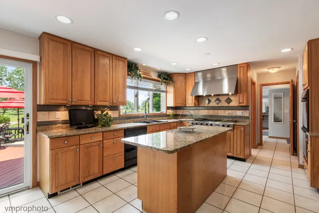a kitchen with stainless steel appliances granite countertop a sink counter space cabinets and a large window