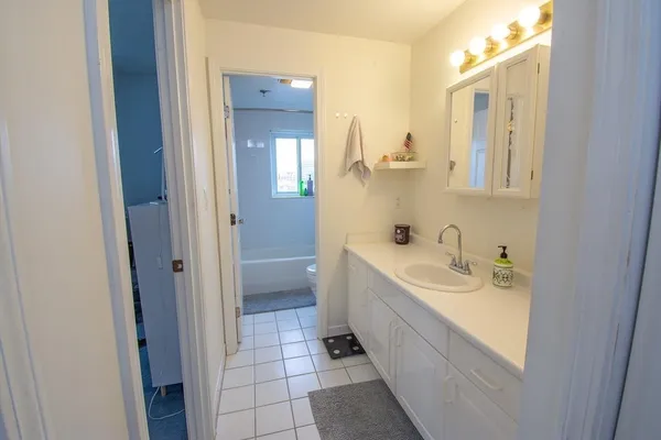 a bathroom with a double vanity sink mirror and bathtub