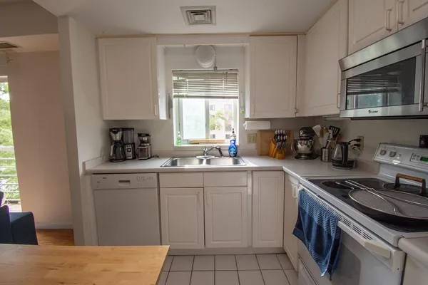 a kitchen with a sink stove top oven and cabinets