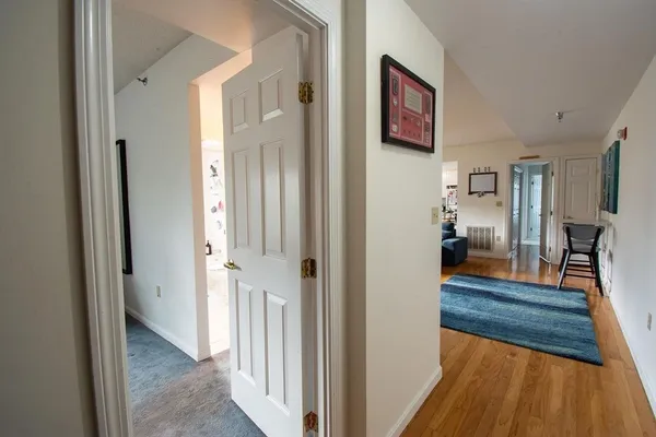 a view of a hallway view with wooden floor and living room