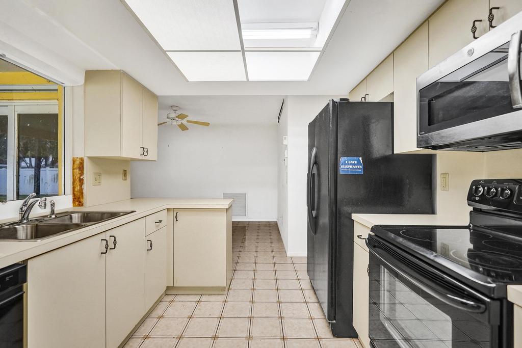 1236 Northwest 15th Street Boca Raton, FL 33486 - Photo 27 of 58 a kitchen with a sink appliances and cabinets