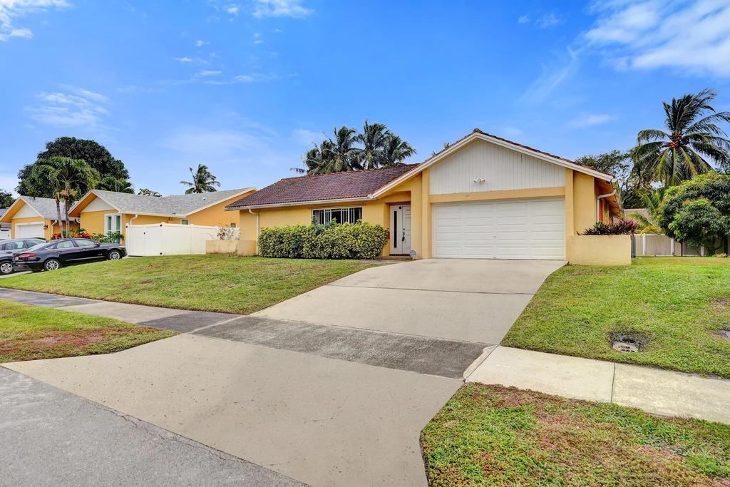 1236 Northwest 15th Street Boca Raton, FL 33486 - Photo 3 of 58 a front view of a house with a yard and garage