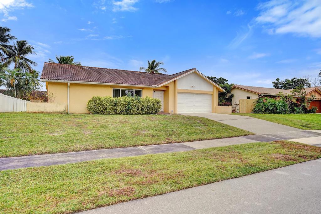 1236 Northwest 15th Street Boca Raton, FL 33486 - Photo 4 of 58 a front view of a house with a garden and yard
