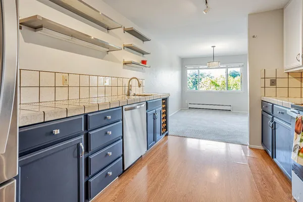 a kitchen with stainless steel appliances a stove and a wooden floor