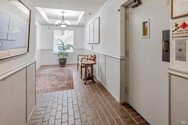 a hallway with wooden floor and chandelier