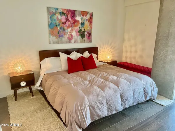 a bedroom with a bed and a painting on the wall
