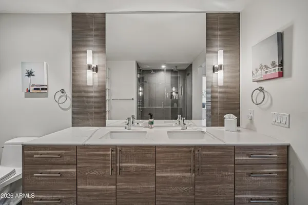 a bathroom with a double vanity sink mirror and shower
