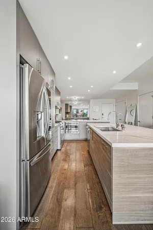 a kitchen with stainless steel appliances granite countertop a stove a sink and a refrigerator