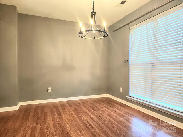 a view of a room with wooden floor and white walls