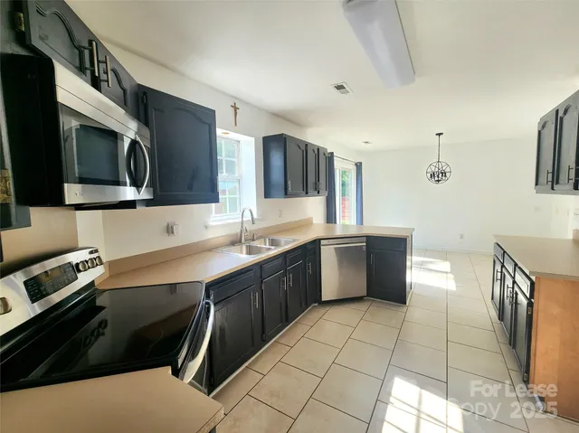 a kitchen with stainless steel appliances a sink cabinets and microwave