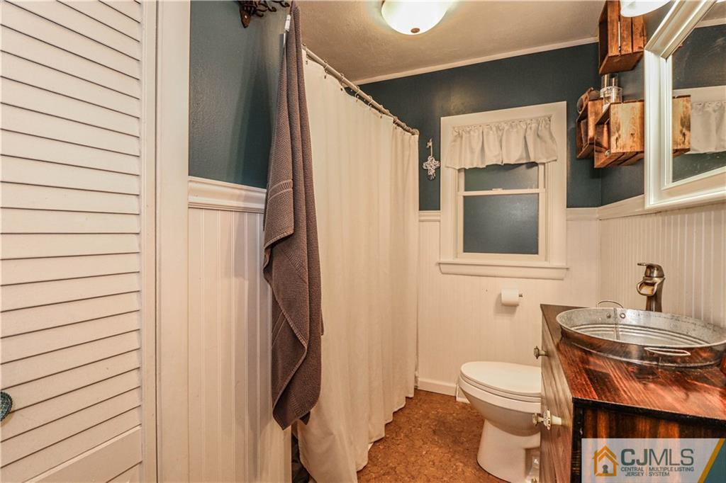 31 Silvers Road Freehold, NJ 07728 - Photo 32 of 46 a bathroom with a toilet a sink and mirror