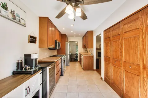 a kitchen with stainless steel appliances sink stove refrigerator and cabinets