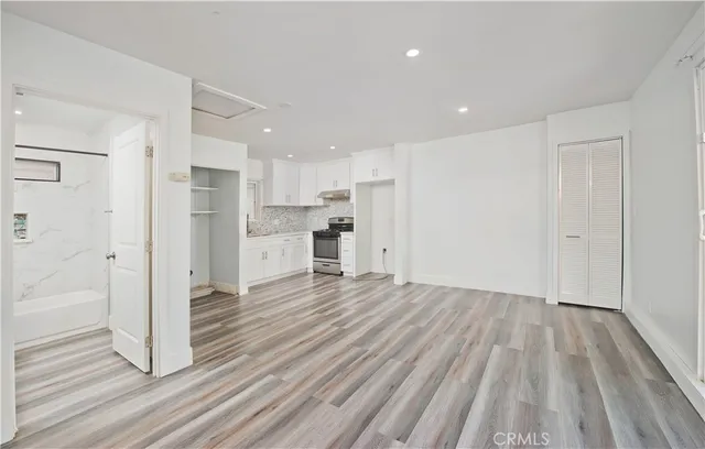 a view of kitchen view wooden floors appliances and cabinets