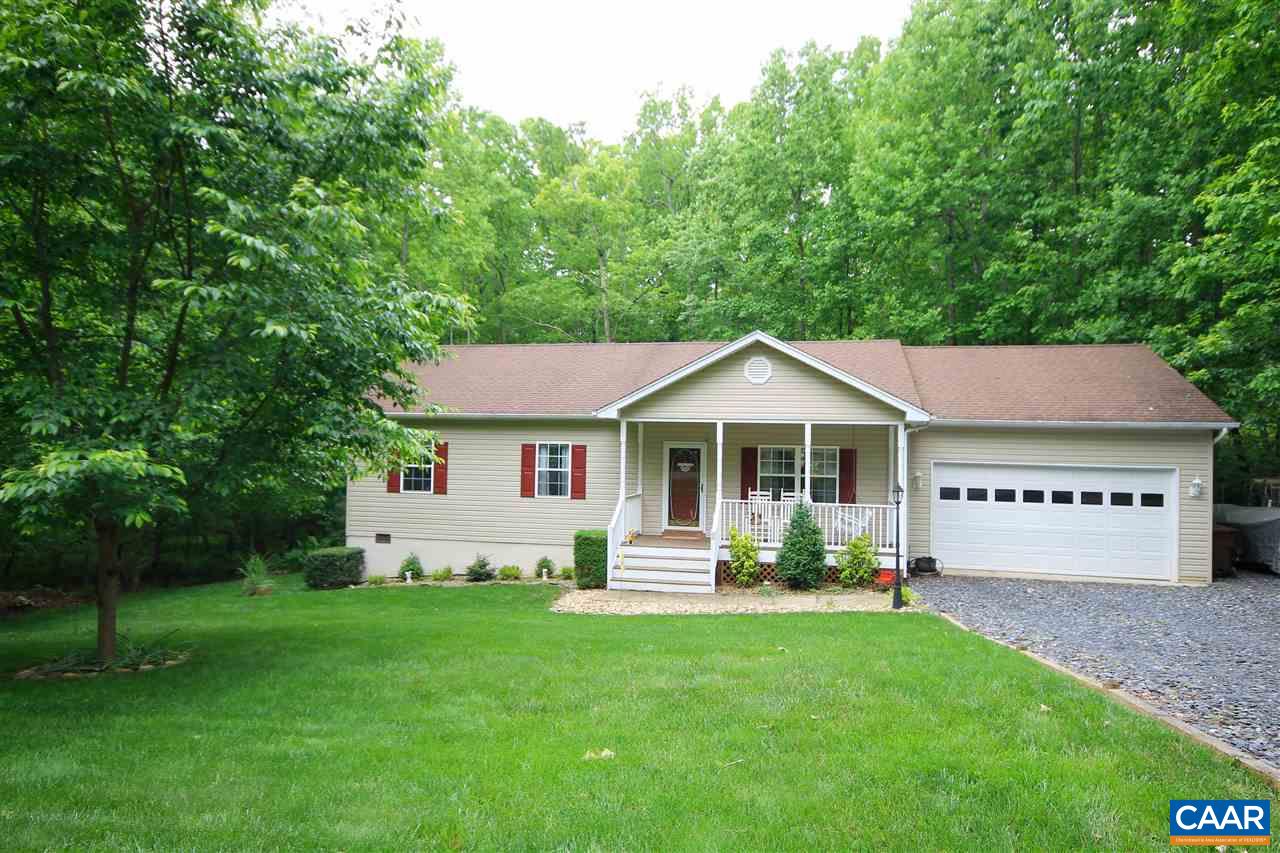 a front view of a house with a yard and green space