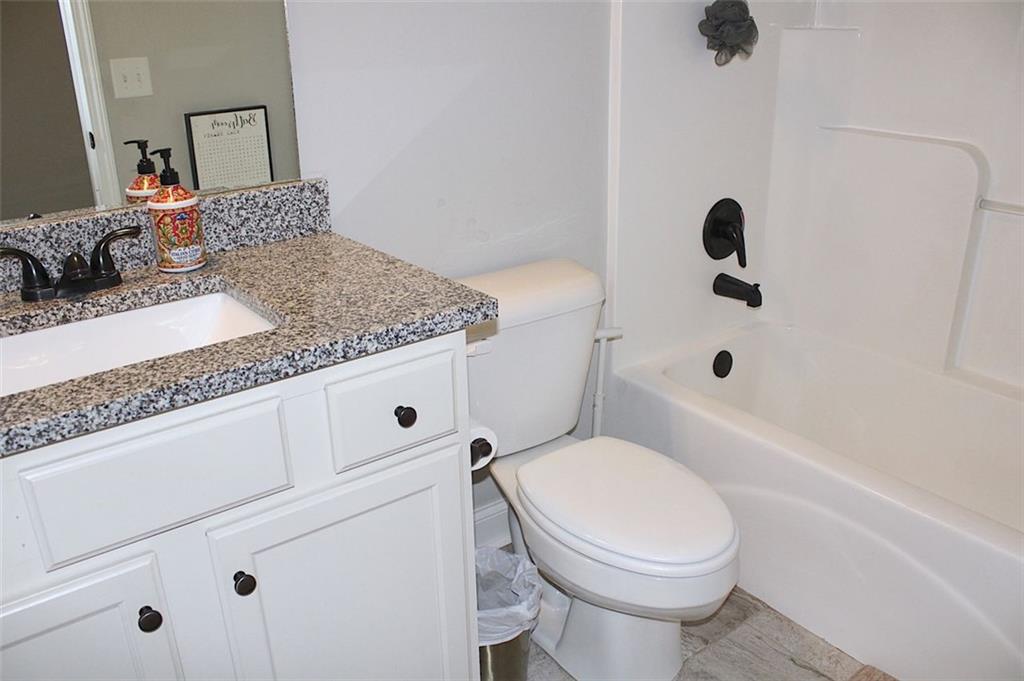 728 Harmony Road Temple, GA 30179 - Photo 27 of 29 a bathroom with a granite countertop toilet sink and mirror