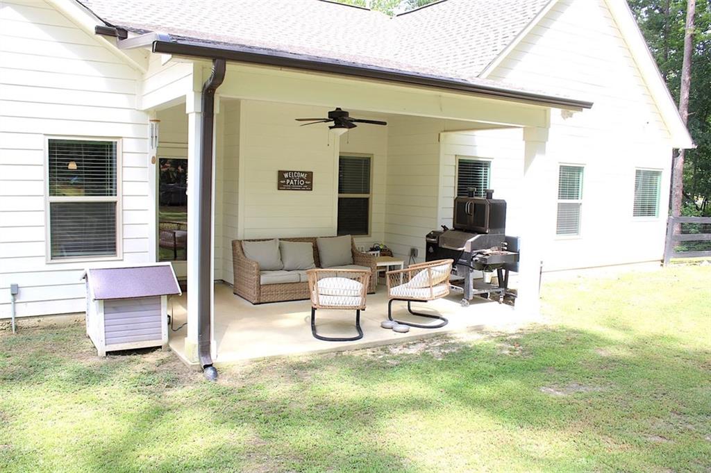 728 Harmony Road Temple, GA 30179 - Photo 29 of 29 a view of a patio with dining table and chairs with wooden fence