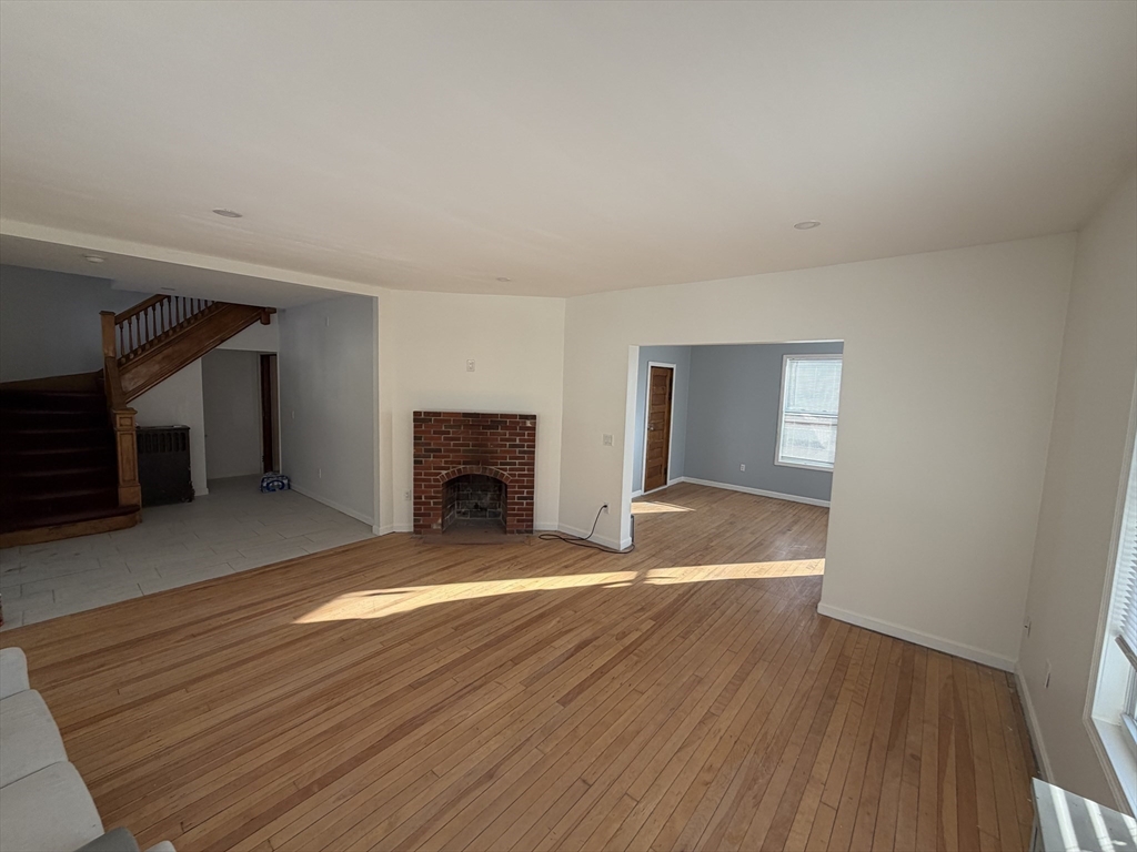 12 Stoneland Road Worcester, MA 01603 - Photo 14 of 36 a view of empty room with wooden floor and fireplace