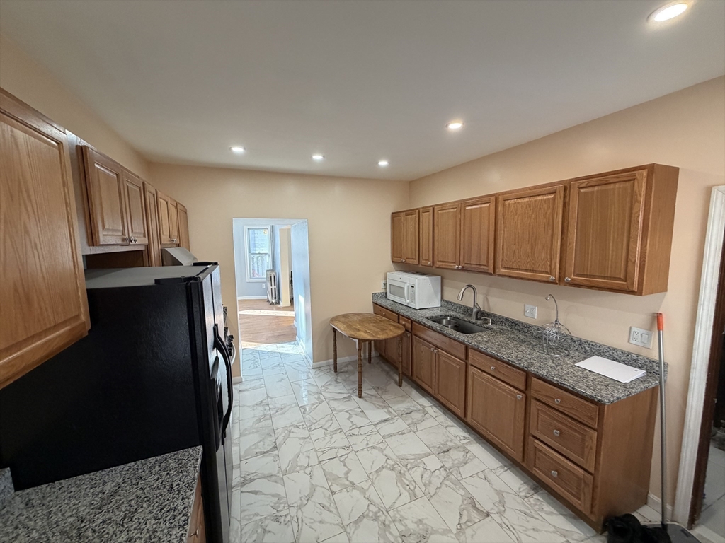 12 Stoneland Road Worcester, MA 01603 - Photo 6 of 36 a kitchen with stainless steel appliances granite countertop a refrigerator and a sink