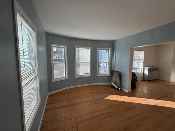 a view of a livingroom with wooden floor and a window