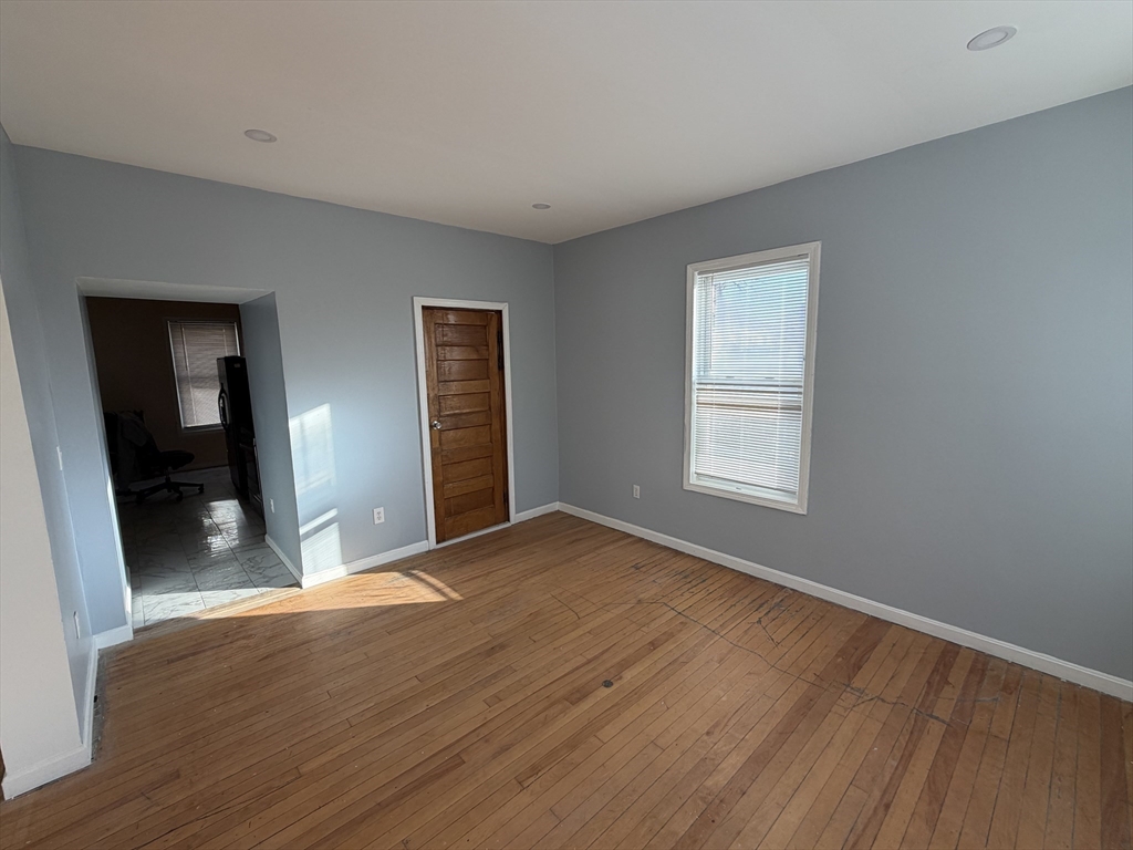 12 Stoneland Road Worcester, MA 01603 - Photo 10 of 36 a view of an empty room with wooden floor and a window