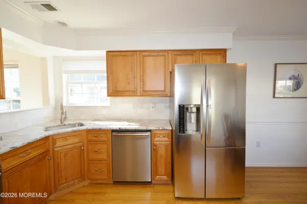 a kitchen with stainless steel appliances granite countertop a refrigerator a stove and a microwave