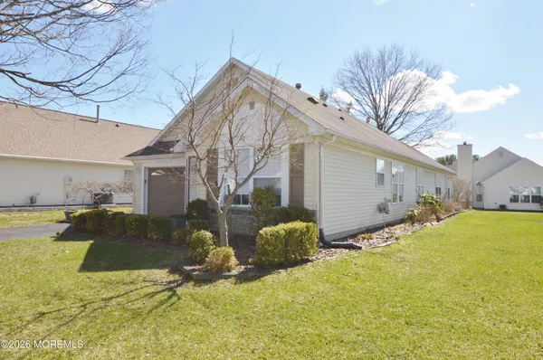 a view of a house with backyard and a tree