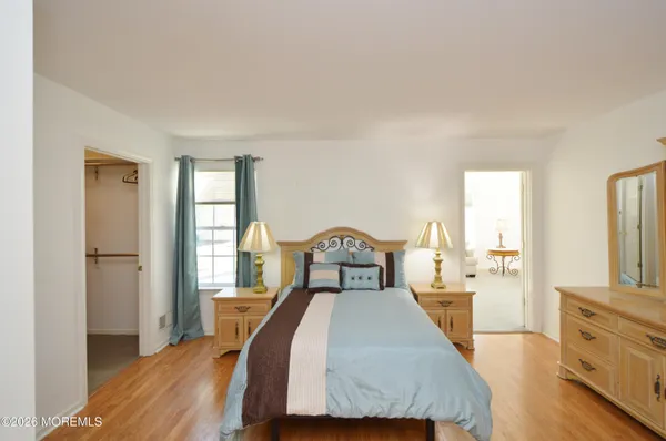 a spacious bedroom with a bed and a dresser