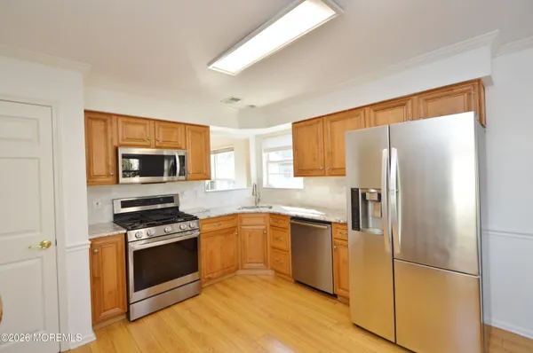 a kitchen with granite countertop a stove a sink and a microwave