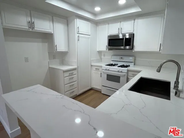 a kitchen with a sink a stove and microwave