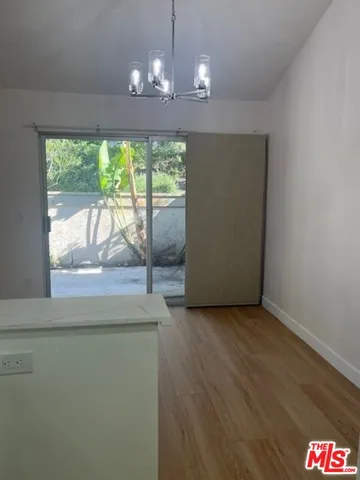 an empty room with wooden floor and outdoor space