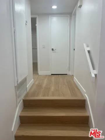 an empty room with wooden floor and mirror