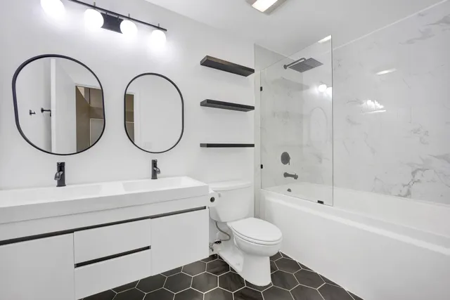 a bathroom with a double vanity sink mirror and toilet