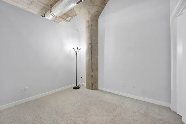 an empty room with a ceiling fan and a window