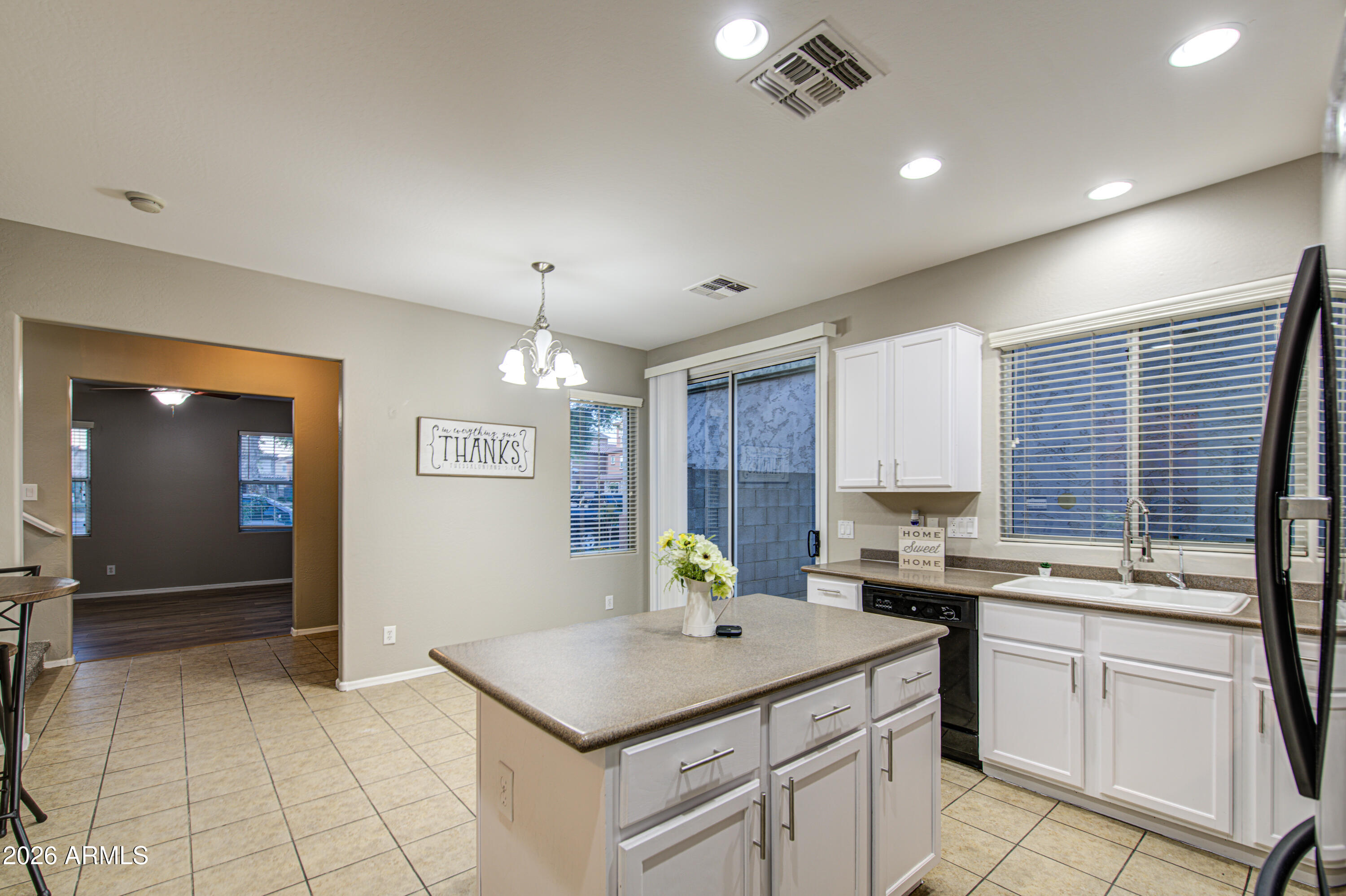 7759 West Monte Vista Road Phoenix, AZ 85035 - Photo 18 of 43 a kitchen with a sink refrigerator and cabinets