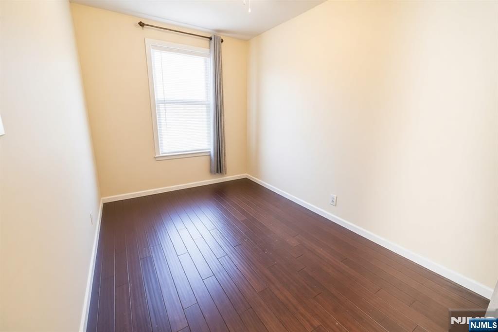 289 Rose Street Newark, NJ 07108 - Photo 12 of 29 an empty room with wooden floor and windows