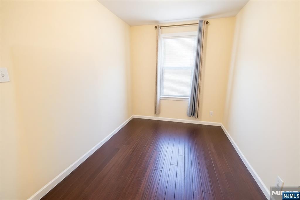 289 Rose Street Newark, NJ 07108 - Photo 13 of 29 a view of an empty room with wooden floor and a window