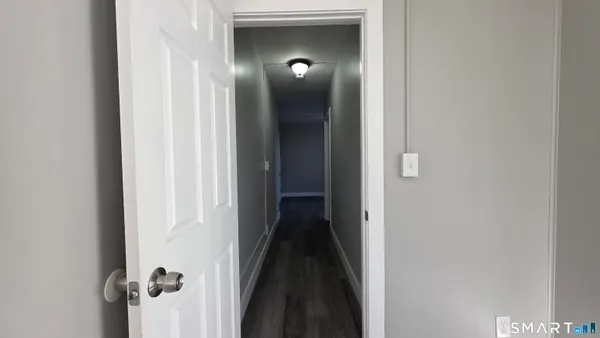 a view of a room with wooden floor and a hallway