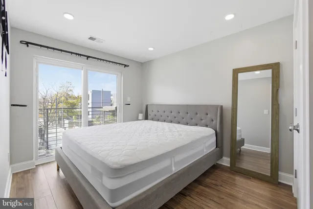 a large bed sitting in a bedroom next to a window