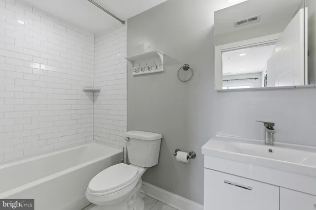 a white toilet sitting next to a bathroom sink