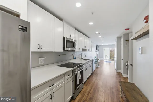 a kitchen with stainless steel appliances sink stove microwave and cabinets