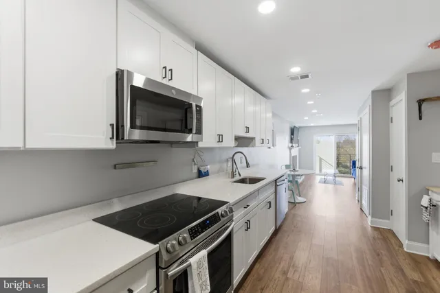 a kitchen with sink stove and cabinets