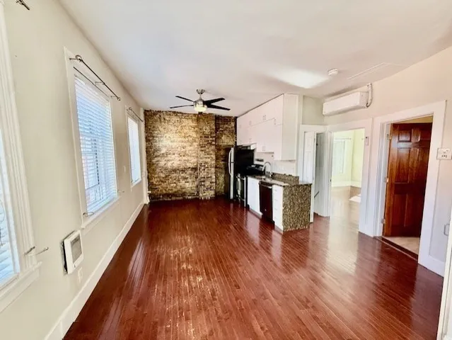 a view of a kitchen with wooden floor and electronic appliances