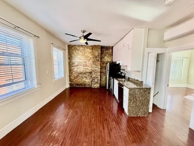 a view of a living room with hardwood floor and a ceiling fan