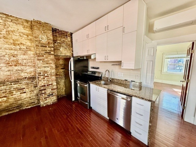 164 Prince Street, Unit 4 Boston, MA 02113 - Photo 3 of 16 a kitchen with granite countertop wooden floors and stainless steel appliances