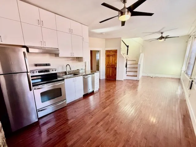 a kitchen with granite countertop a refrigerator and a stove top oven