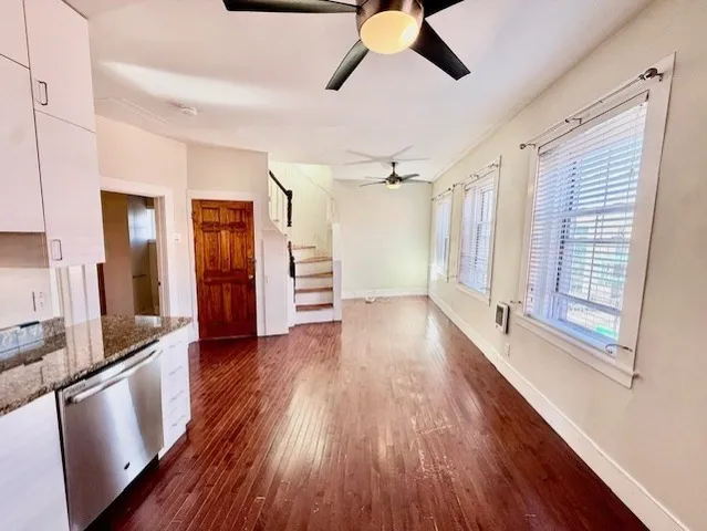 a view of a hardwood floor in an empty room with a window