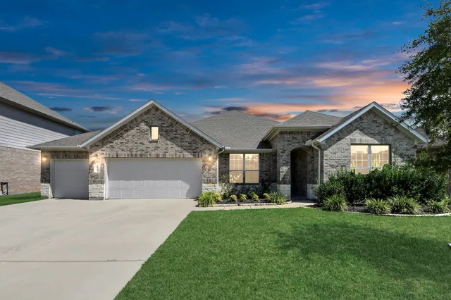 a view of a house with brick walls and a yard