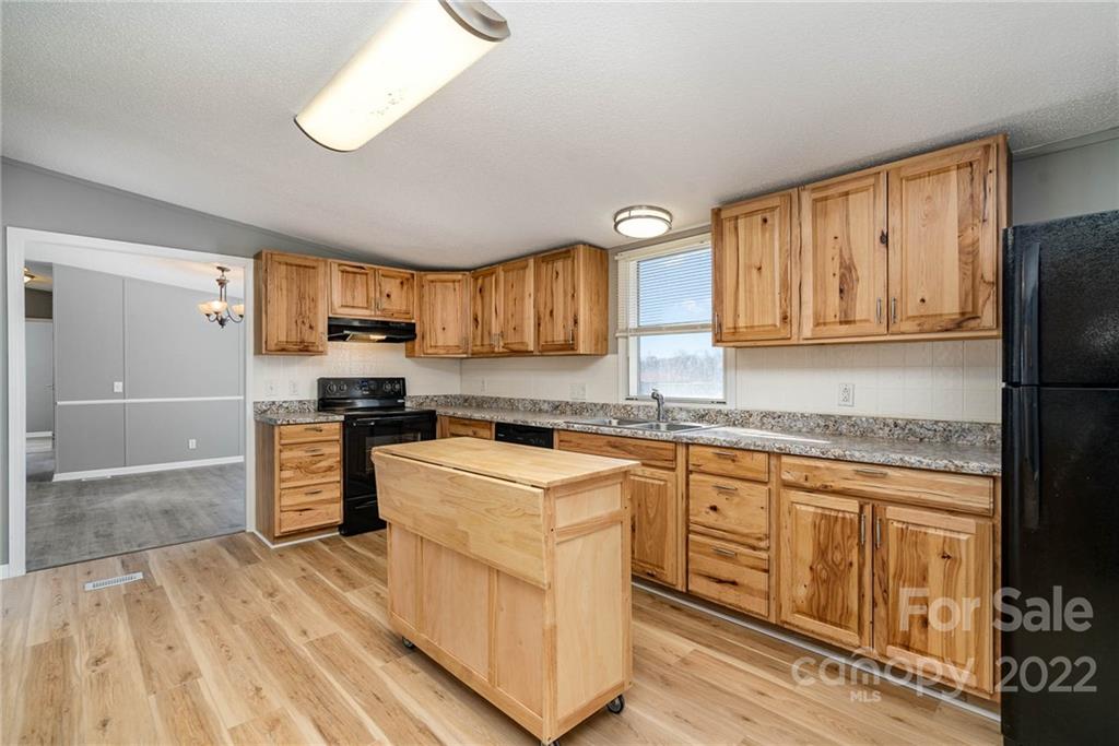 4289 Henry Dellinger Road Maiden, NC 28650 - Photo 28 of 42 a kitchen with stainless steel appliances granite countertop a stove a sink dishwasher and a refrigerator with wooden floor