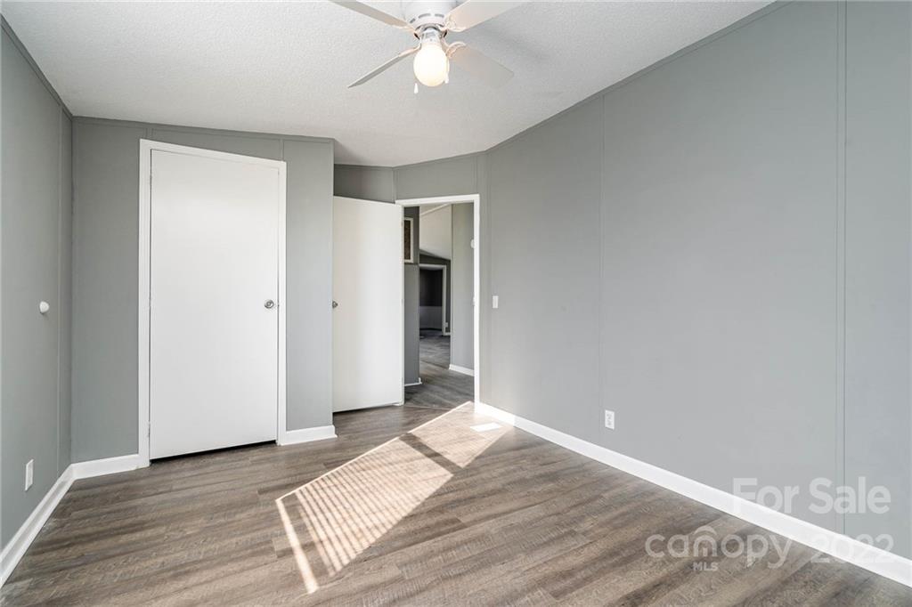 4289 Henry Dellinger Road Maiden, NC 28650 - Photo 32 of 42 an empty room with wooden floor and fan